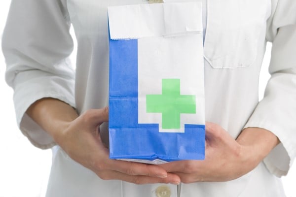 A pharmacist holding a prescription medication bag