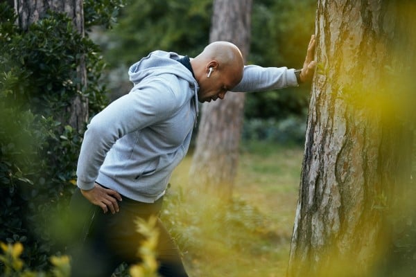 A man pauses while exercising due to pain
