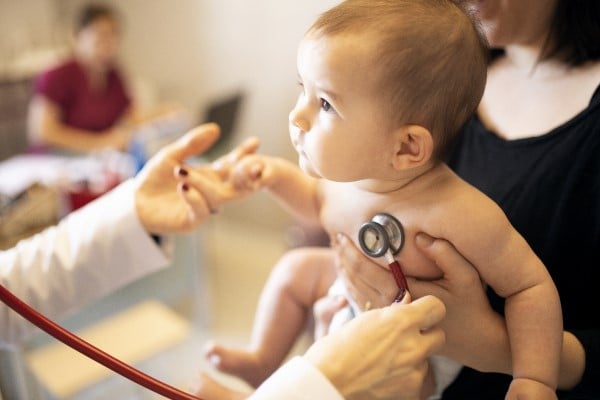A baby being checked with a stethoscope