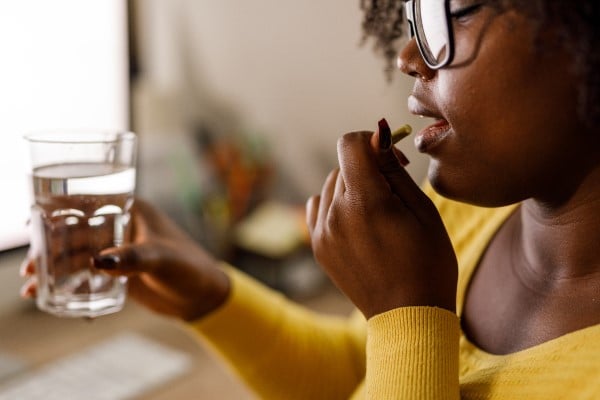 A woman taking pills with water