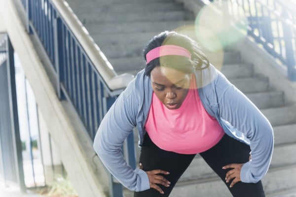 An exercising woman stopping to catch her breath