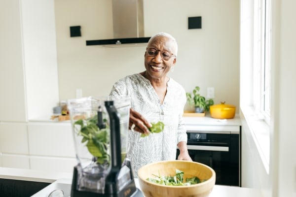 A woman making a healthy green smoothie