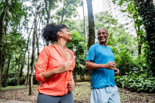 A father and daughter jogging in a park