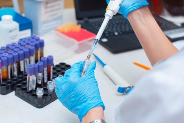 hands in a medical laboratory with vials of fluids