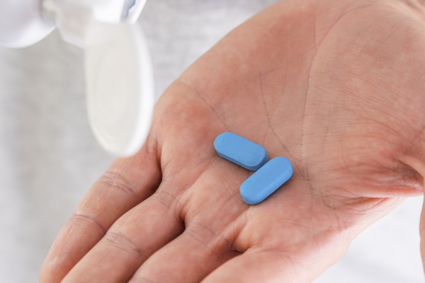 hand holding two blue pills