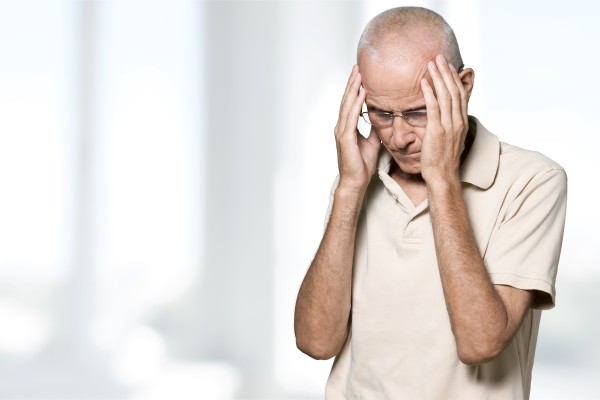 A man experiencing a dizzying headache