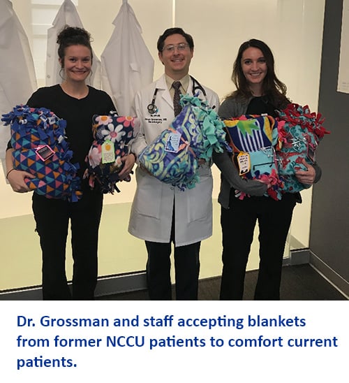Dr. Grossman and staff accepting blankets from former NCCU patients to comfort current patients