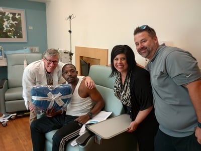 A MetroHealth patient receiving a gift blanket with Dr. Michael Harrington present