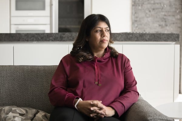 woman looking pensive sitting on couch