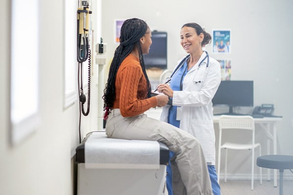 Doctor meeting with woman in exam room