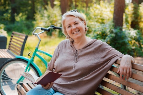 woman sitting on park bench smiling