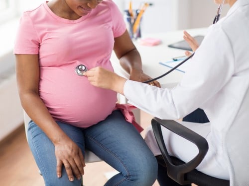 provider with stethoscope on pregnant woman's stomach