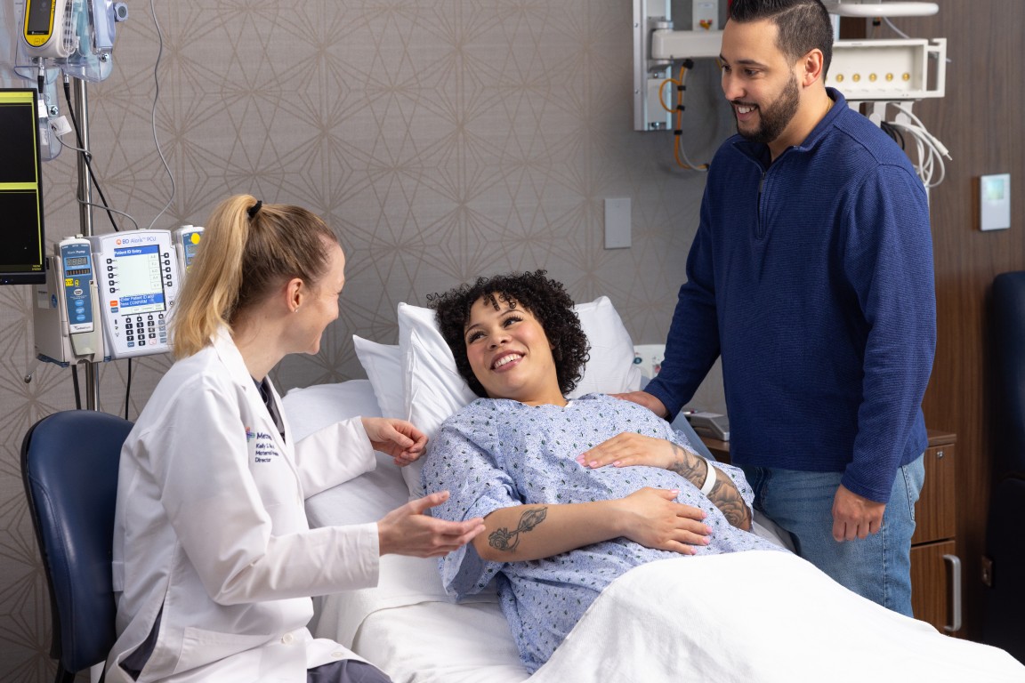 An expecting mother in the Birthing Center with husband and obstetrician