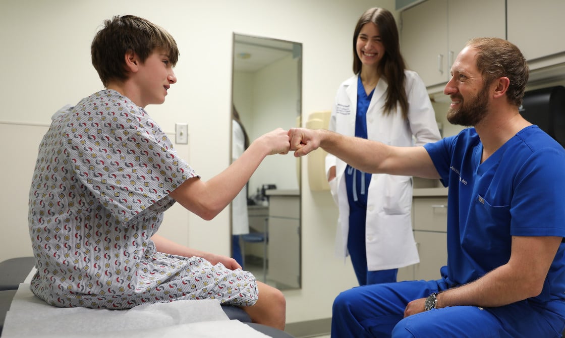 A pediatric patient fist bumping Dr. Mistovich after a consultation