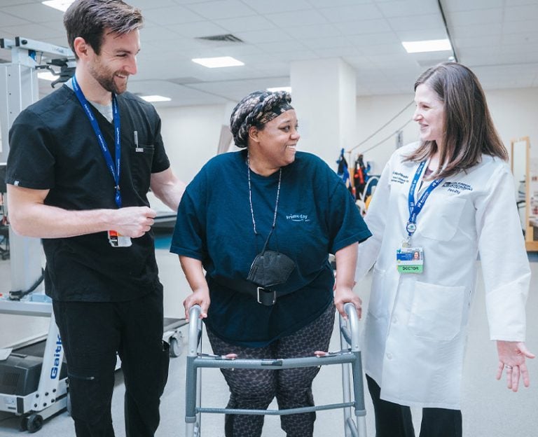 A patient walking with MetroHealth providers