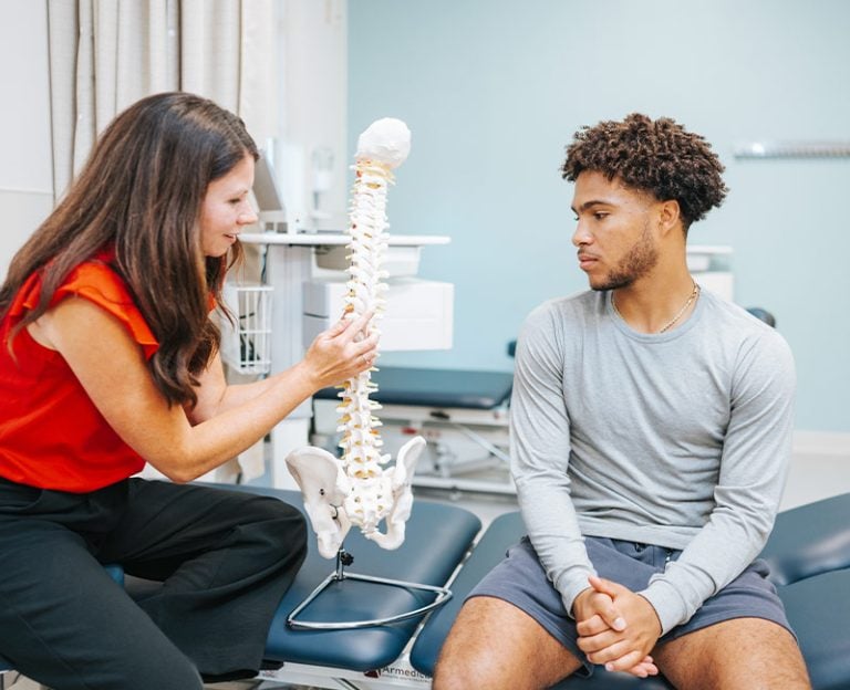 A Rehabilitation provider using a model spine as an example