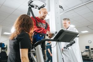 A patient in a harness walking on a treadmill