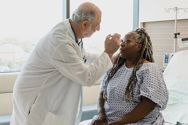 A provider checking a patient's eyes for signs of concussion
