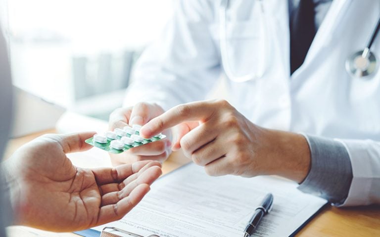 Provider showing bubble pack of pills to a patient