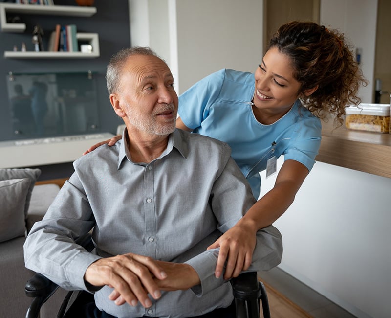 A provider checking on a patient in a wheelchair