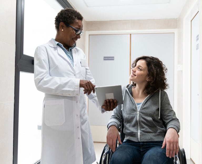 A patient in a wheelchair getting information from her provider