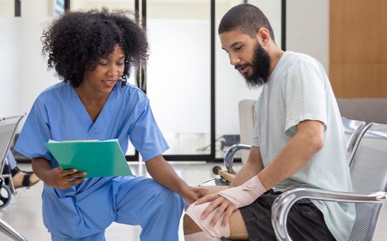 A provider checking the injured knee of a Rehabilitation patient
