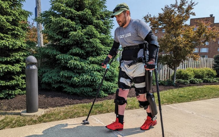 Man with leg braces and arm braces walking