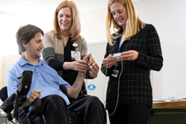 A patient in a wheelchair having his wrist and finger motion checked