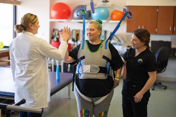 Patient with walking assistive technology on, giving provider high-five
