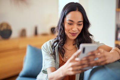 multicultural woman face timing with person on smartphone