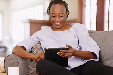 Woman on couch with computer talking to physician