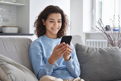 Woman using smartphone for virtual visit with doctor