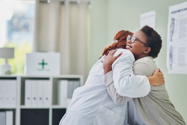A patient and her doctor hugging in celebration