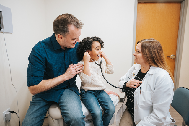 Young female patient with father and provider in exam room
